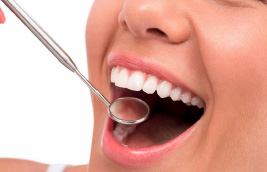 An image of a person with an open mouth, receiving dental care in the form of a tooth cleaning device.