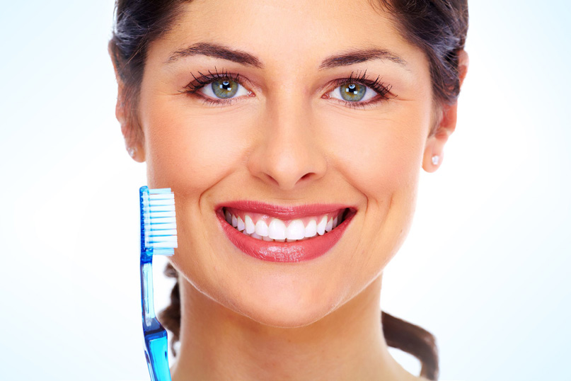 A woman s face with a large blue toothbrush superimposed on her skin, showcasing dental hygiene.